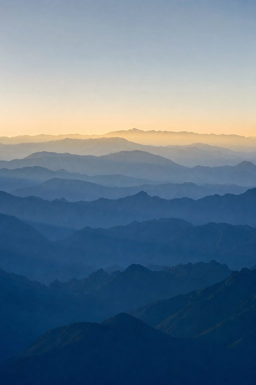 Layered mountain ridgelines fading into morning light